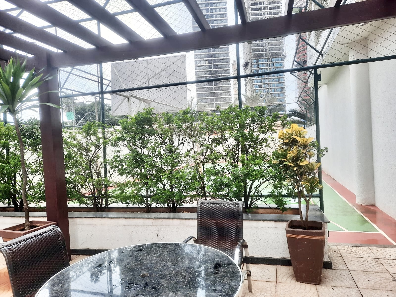 Varanda gourmet com pergolado e churrasqueira — Edifício Olímpia